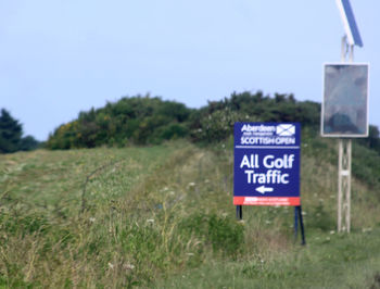 Close-up of signboard against clear blue sky