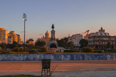 Buildings in city against sky during sunset