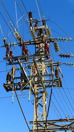 View of electricity pylon against clear blue sky