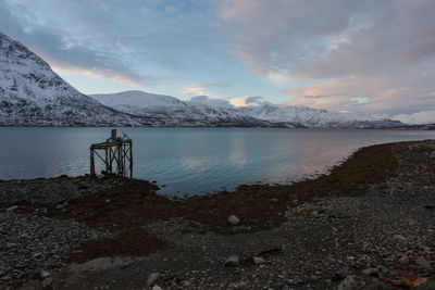 Scenic view of sea and mountains against sky at dusk