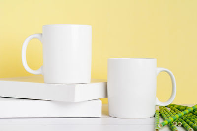 Close-up of coffee cup on table against wall