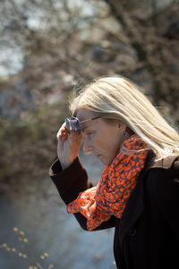 Woman wearing sunglasses looking at lake