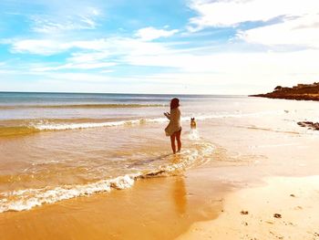 Full length of woman on beach against sky