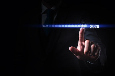 Midsection of man holding illuminated lighting equipment