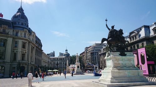 Statue of historic building in city against sky