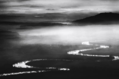 Scenic view of mountain range against cloudy sky