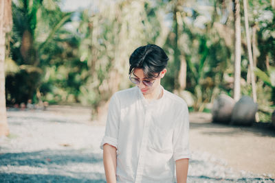 Young man looking away while standing outdoors