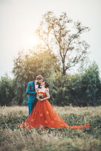 Newlywed couple kissing on field