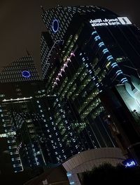 Low angle view of illuminated buildings against sky at night