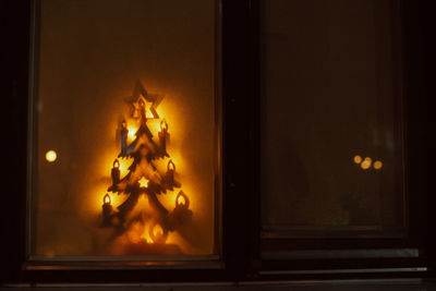 Illuminated christmas lights on window at home