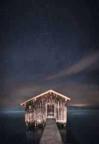 Pier over sea against sky at night