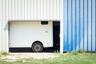 Vintage car on field against blue door