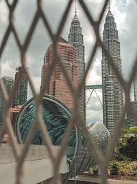 Low angle view of chainlink fence and building against sky