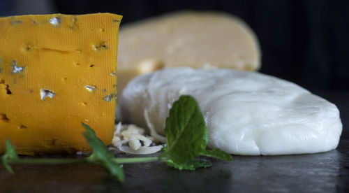 Close-up of various cheese on black table