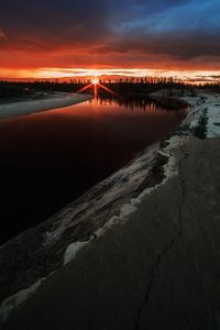 Scenic view of river against sky at sunset