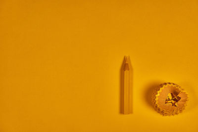 High angle view of colored pencils on yellow background