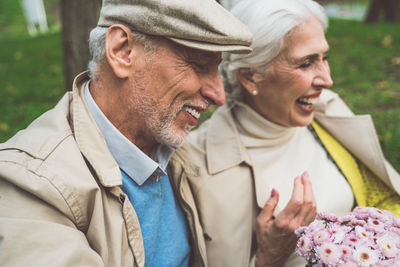 Laughing senior couple sitting at park