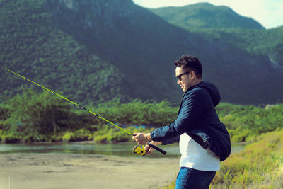 Side view of man fishing in lake