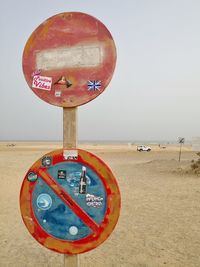 Information sign on beach against sky