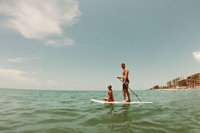 View of couple paddleboarding