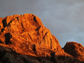 Low angle view of rocky mountains against sky