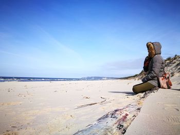 Woman on beach against clear sky