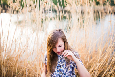 Young woman standing by plants