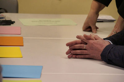 Close-up of people hands on table with colorful papers