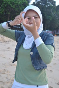 Young woman gesturing while standing at shore