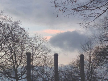 Low angle view of bare tree against cloudy sky