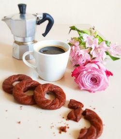 Close-up of dessert and coffee with rose on table