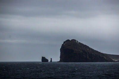 Scenic view of rock formation in sea against sky