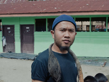 Portrait of young man standing against wall