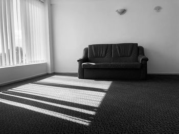 Sunrays going through the blinds in a minimalist black and white room