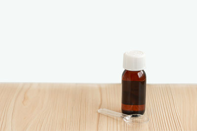 Close-up of beer bottle on table against white background