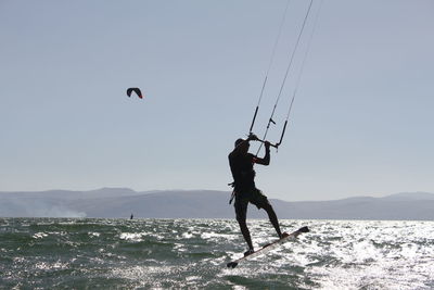 Man surfing on sea against sky