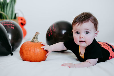 Close-up portrait of cute baby lying on bed