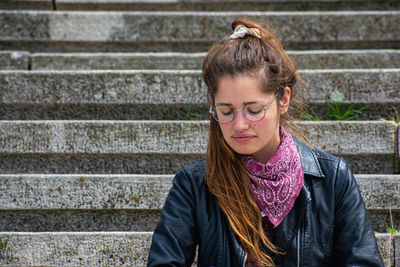 Young woman standing against wall