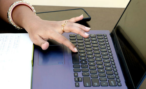 Cropped hands using laptop