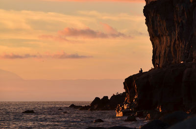 Silhouette of rock formations at seaside