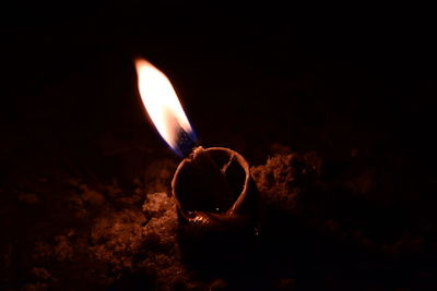 Close-up of lit candle in the dark