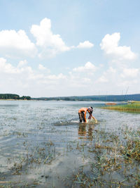 Shirtless farmer working in rice paddy