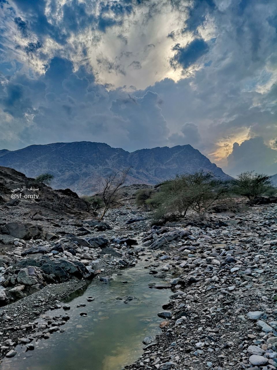 SCENIC VIEW OF STREAM BY ROCKS AGAINST SKY