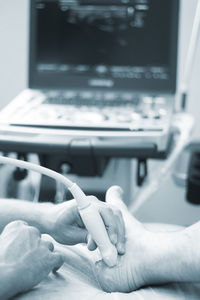 Cropped hands of doctor operating patient
