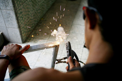 Midsection of man welding metal in workshop