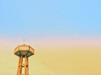 Low angle view of tower against clear sky during sunset