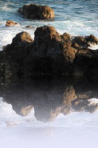 Rocks in sea against sky