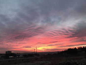 Silhouette landscape against dramatic sky during sunset