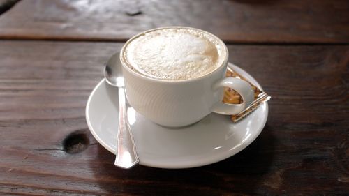 Close-up of coffee cup on wooden table