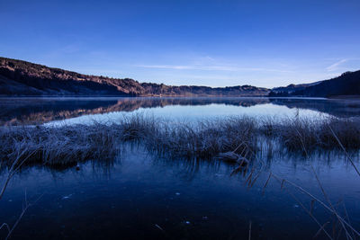 Scenic view of lake against blue sky